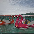 Pink And Orange Flamingo Paddle Boats Carrying People On Water With Canopies