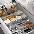 Well Organized Kitchen Drawer With Bowls Plates Utensils And Glass Jars