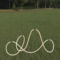 Modern Curved Loop Chandelier Hanging In Outdoor Grassy Field With Trees
