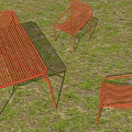 Outdoor Red Woven Table and Chair Set on Sandy Ground with Grass and Sunlight Shadows