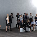 Group of Business Professionals Standing and Sitting in Office With Gray Wall and Wooden Floor