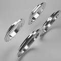 Four Polished Stainless Steel Industrial Flanges with Bolt Holes and Smooth Surface
