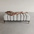 Soft Upholstered Ottoman with Light Gray Tufted Surface and Metallic Legs with Draped Scarf