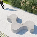 Concrete Outdoor Chair With Unique Curved Design In Garden Patio With Greenery And Stone Path