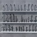 Various Modern Faucets Arranged on White Shelves Against Gray Concrete Wall