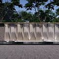 Modern Outdoor Feature Wall With Metal Texture Design Surrounded by Trees and Paved Ground