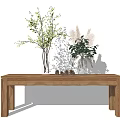 Decorative Vase with Green Plants and Flowers on Wooden Table with Pinecones Against White Wall