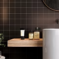 Washbasin with White Pedestal Wooden Countertop Black Tiled Wall Round Gold Frame Mirror and Towels