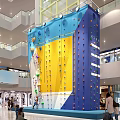 Indoor Rock Climbing Wall With Vibrant Blue Yellow Sections And Climbing Holds In Shopping Mall