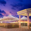 Evening Commercial Street Featuring White Canopies Blue Domed Building Paved Ground And Lighting