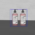 Two LA FABRIQUE Liquid Hand Soap Bottles On Grey Surface With Clean Design