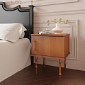 Brown Wooden Nightstand With Gold Handle Cabinet Door And White Vase With Flowers
