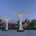 Illuminated Mushroom Shaped Pergolas With Hollowed Out Design Among Trees In Evening Square