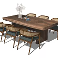 Wooden Dining Table Set With Woven Back Chairs Blue Cushions Vase And White Flowers