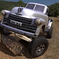 Silver Vintage Truck With Off Road Tires Parked On Rock In Grassland
