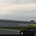 Modern Industrial Warehouse Building with Large Glass Windows Red Yellow Accents and Surrounding Greenery