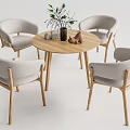 Modern Round Wooden Dining Table With Four Light Gray Fabric Chairs And Decorative Vase