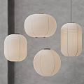 Four White Paper Pendant Lights of Various Shapes Hanging Against Gray Wall