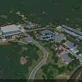 Aerial View of Industrial Factory Surrounded by Lush Forests River and Mountain Backdrop