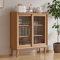 Minimalist Wooden Sideboard With Glass Doors And Top Decorative Items Near Green Plant