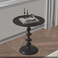 Black Round Side Table With Magazine Candle Holder and Layered Base on Wooden Floor
