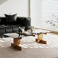 Glass Coffee Table With Wooden Legs On Rug Near Black Leather Sofa And Sunlight Patterns
