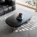 Modern Black Marble Oval Coffee Table With Wooden Bowl And Books On Patterned Rug