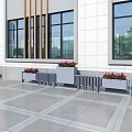 Modern Outdoor Garden Planters With Red Flowers Along Building Exterior On Paved Ground