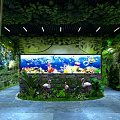 Lush Green Plant Decor With Tree Branch Archway And Large Aquarium Featuring Colorful Fish