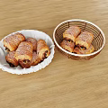 Chocolate Croissants in White Plate and Wicker Basket on Wooden Table