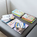 Colorful Books And Magazines Stacked On Table With Pen And Notebook