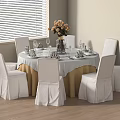 Round Dining Table Set with White Tablecloth Golden Skirt Six White Chairs and Flower Arrangement