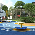 Modern Children's Playground With Blue Floor Central Tree Colorful Structures And Green Plants