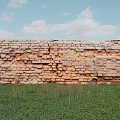 Ancient Weathered Scenic Wall with Orange Gray Bricks in Green Grass Field and Blue Sky
