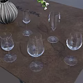 Clear Wine Glasses Arranged On Brown Table With Decorative Vase And White Flowers