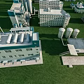 Aerial View Of Industrial Factory Buildings With Storage Tanks And Green Grass