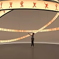 Interactive Circular Art Installation Featuring Orange Human Figures And Suspended Illuminated Rings 3d model