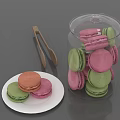 Colorful Macarons Arranged in Glass Jar and on White Plate with Wooden Tongs