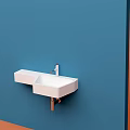 Minimalist White Wall Mounted Washbasin With Modern Faucet On Blue Wall Background
