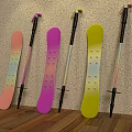 Pink Purple Yellow Snowboards And Ski Poles Leaning Against Wall On Wooden Floor