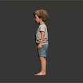 Child in Light Gray T-Shirt and Blue Shorts Standing Barefoot Against Dark Background