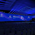 Modern Conference Stage Design With Blue Lighting Large Screens And Arranged Seats Setup