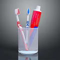 Essential Daily Household Essentials With Two Toothbrushes And Toothpaste Tube In Transparent Glass Cup