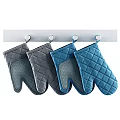 Gray And Blue Quilted Oven Mitts Hanging On Kitchen Hooks