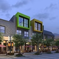 Modern Commercial Street with Green Yellow Facades Outdoor Seating Trees Umbrellas in Evening Sky