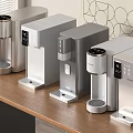 Various Silver Gray Instant Heating Water Dispensers On Wooden Tabletop With Window Blinds Geometric Art