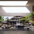 Rockery Stones With Cascading Waterfall And Decorative Green Plants In Indoor Garden Setting