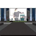 Person Standing On Stage With Blue Beige Walls Green Lawn Area And Small Pavilion Benches