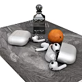 Stylish Silver Earbuds with Charging Case on Grey Tabletop and Black Bottle Orange Fruit