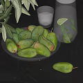 Green Mangoes on Glass Plate with Water Pitcher Lemon Slices and Ice Cubes on Table